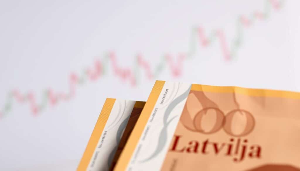 A detailed close-up view of Latvian government bonds, or "obligācijas Latvija," against a clean, professional backdrop. The bonds are positioned prominently in the foreground, their glossy surfaces reflecting a warm, natural lighting. The middle ground features a subtle grid pattern or financial data visualization, hinting at the analytical and investment context. The background is a muted, neutral palette, allowing the financial instruments to take center stage. The overall mood is one of stability, reliability, and institutional credibility - qualities well-suited for a serious discussion of fixed-income investment opportunities in Latvia.