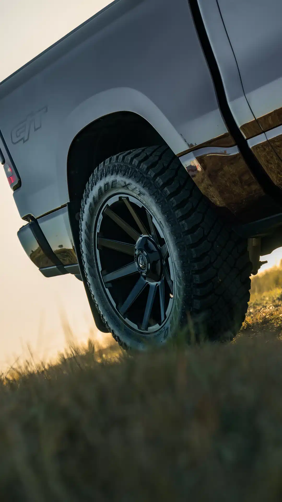 Close-up of a truck wheel on grassy terrain
