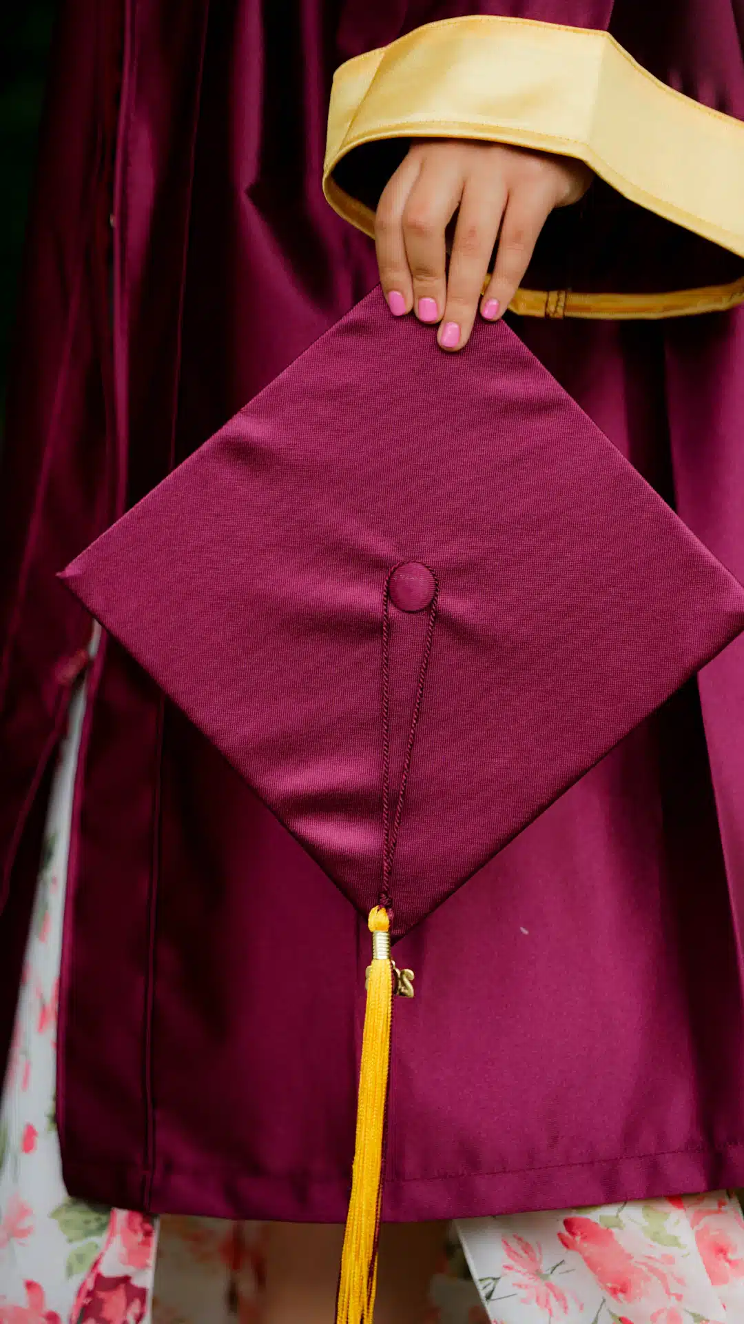 woman holding purple mortar board wearing toga