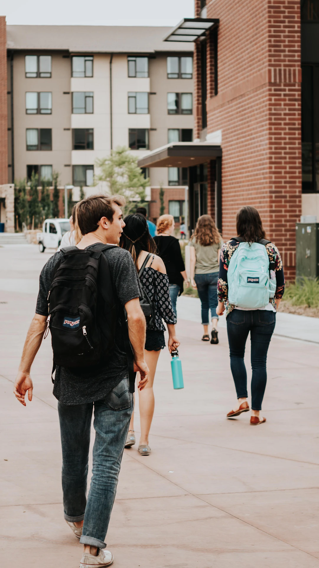 a group of people walking on a sidewalk