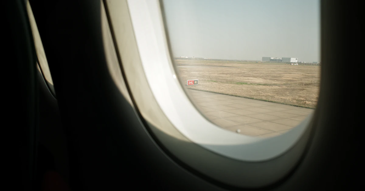 View from airplane window of tarmac and buildings