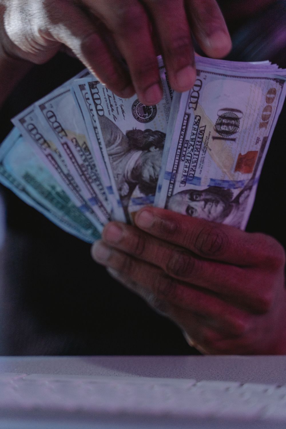 A detailed close-up of hands holding and fanning US dollar bills, showcasing financial concepts.